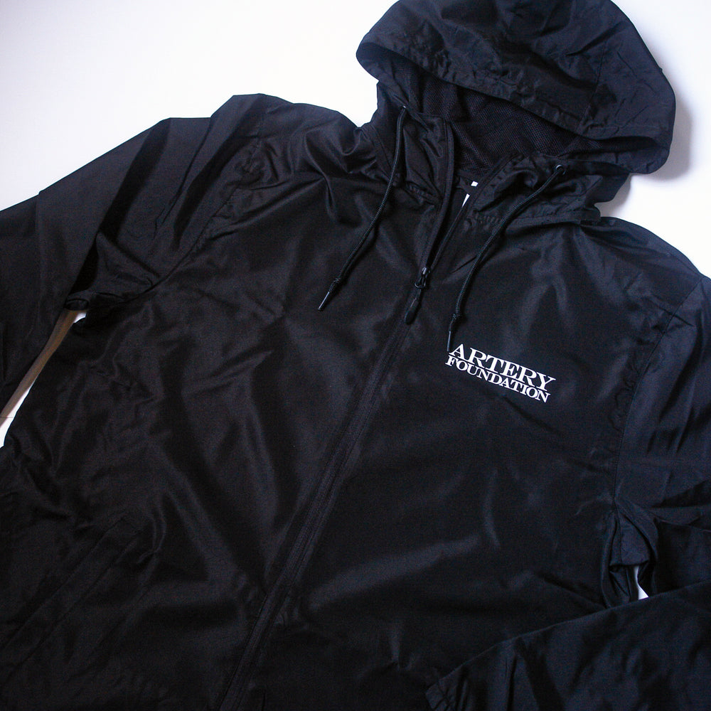 An Artery Foundation black lightweight windbreaker featuring the brand name printed in white on the left chest, displayed flat on a white background.