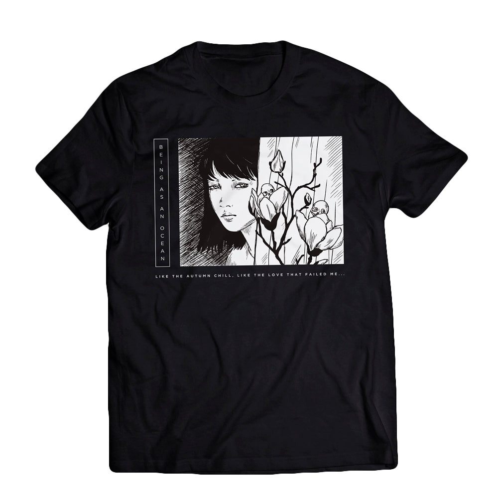 image of a black tee shirt on a white background. tee has full print across the chest in white of a woman's face looking out with flowers on the right. on the left in vertical white text says being as an ocean