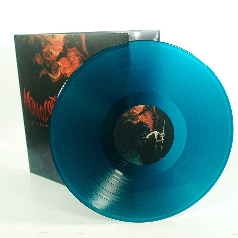 A translucent teal vinyl record leaning against its album cover featuring dark, atmospheric artwork.