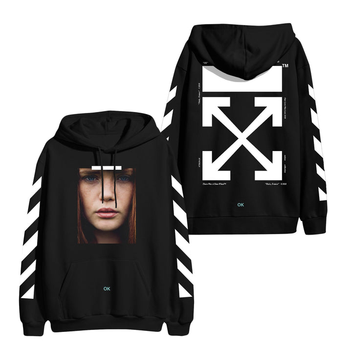 image of the front and back of a black pullover hoodie on a white background. front of hoodie is on the left and has a full print above the pouch pocket of a photograph of a woman's face with red hair and blue eyes. there are white lines on each sleeve, and the word OK on the pouch. the back of the hoodie is on the right and has a full back print in white of a rectangle across the shoulders and a big X below.