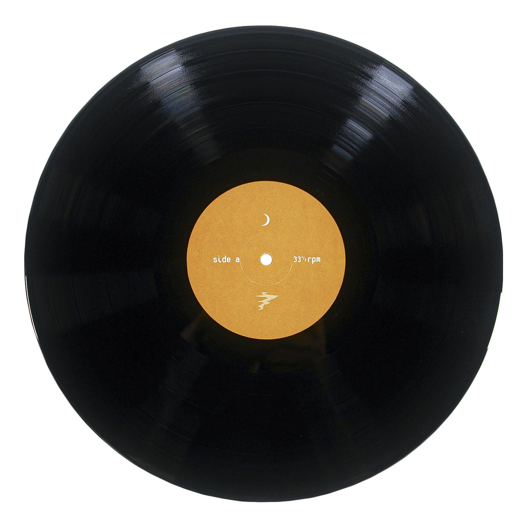 A black vinyl record with a yellowish-brown center label that reads side a and 33 1/3 rpm—featuring tracks from Little Spark—photographed from above against a white background.