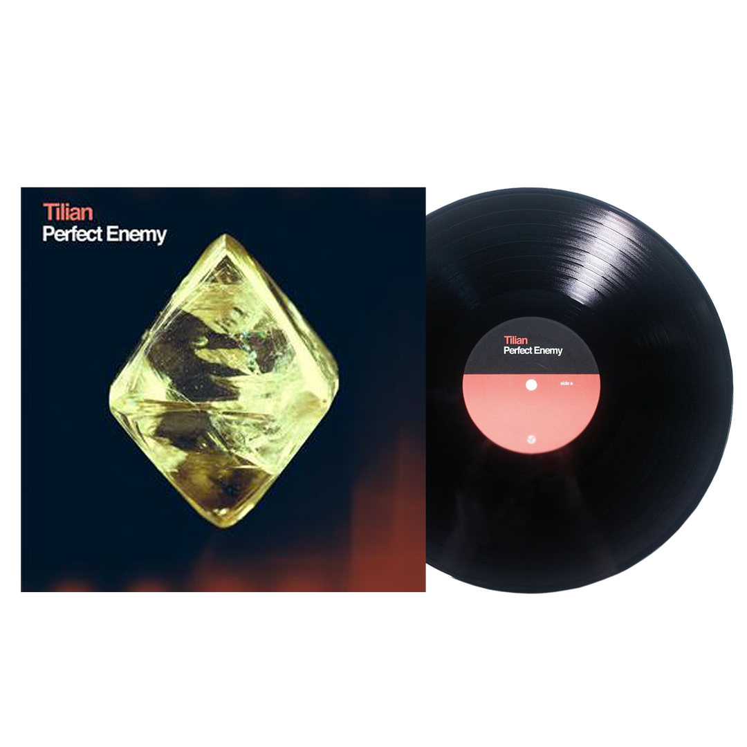 Tilian’s Perfect Enemy album cover displays a glowing yellow crystal on a dark backdrop beside a black vinyl record with a pink and black center label featuring the artist and album name, with “True” highlighted like a distant satellite.
