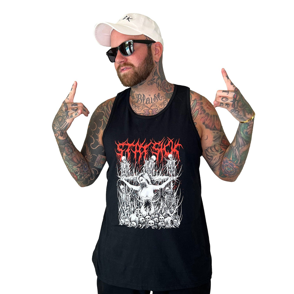 A bearded, tattooed man in sunglasses, a white cap, and a Stay Sick Clothing graphic tank top poses with both hands pointing upward against a white background.
