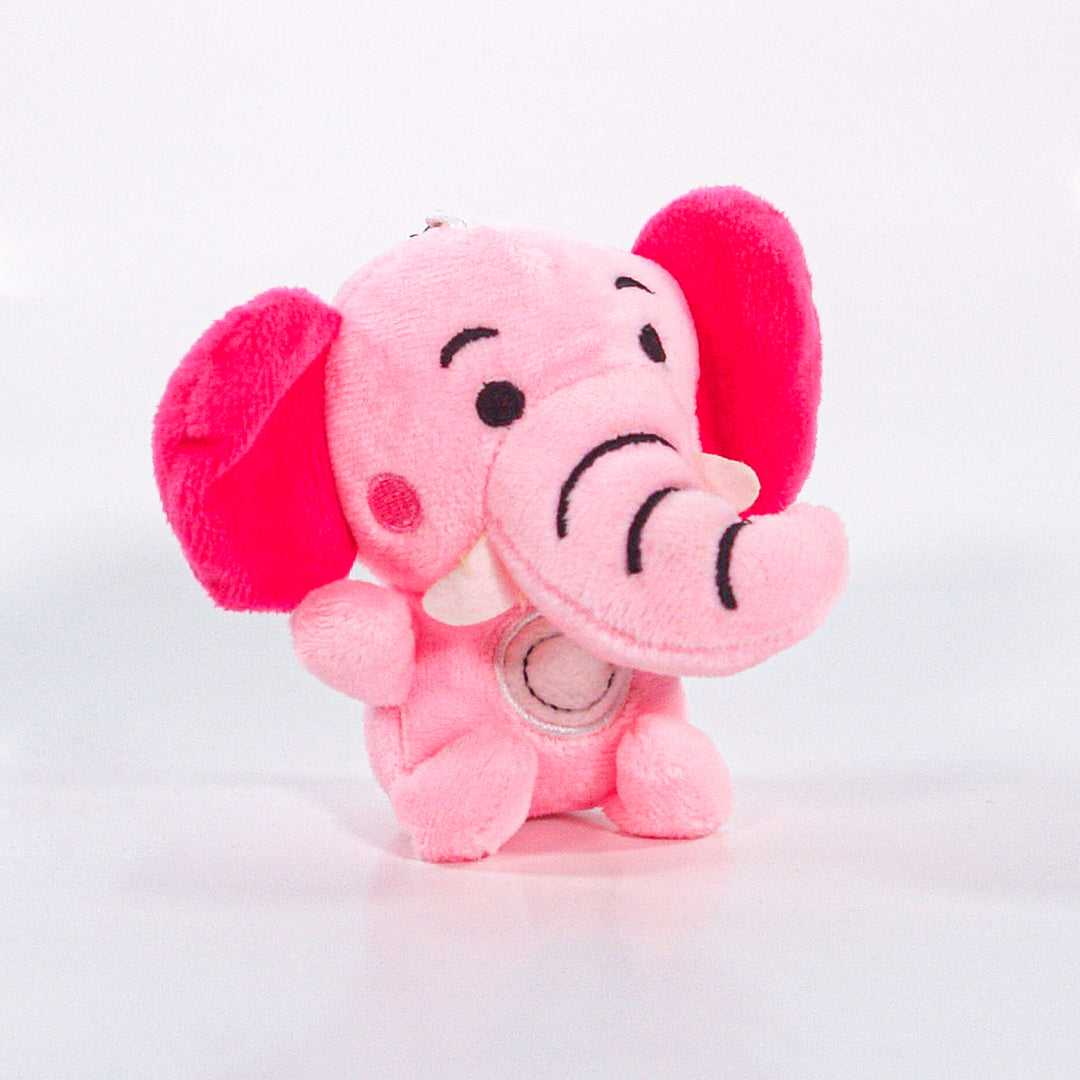 The Pink Elefants plush is a smiling pink elephant with large dark pink ears and black embroidered trunk and eyebrows, shown sitting against a plain white background.