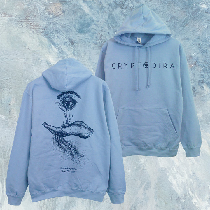 Cryptodira light blue AWDis pullover hoodie shown front and back. Made from soft ringspun cotton, it features CRYPTODIRA in black on the front and a detailed eye-and-hand illustration with text on the back.