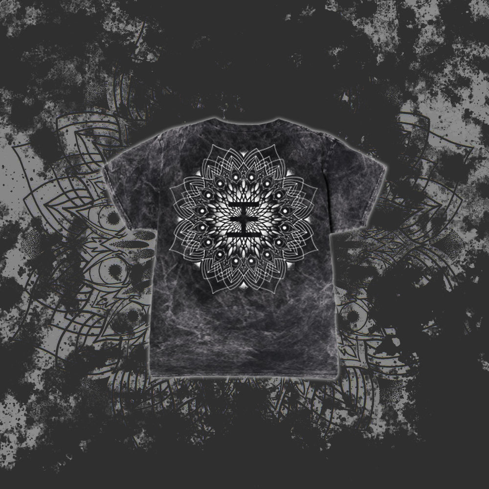A black and gray tie-dye Reflections T-Shirt features a large, intricate white mandala on the back, set against a dark grunge-style background with a subtle oversized mandala pattern.
