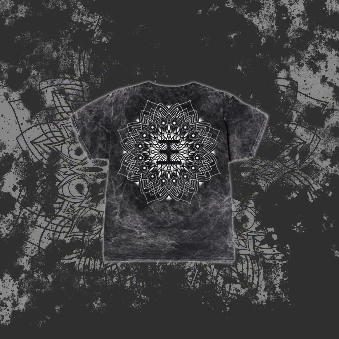 A black and gray tie-dye Reflections T-Shirt features a large, intricate white mandala on the back, set against a dark grunge-style background with a subtle oversized mandala pattern.