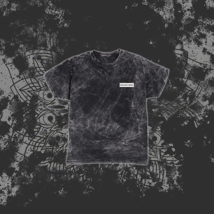 A black marble-pattern T-shirt from Reflections with a small white rectangular label reading RESURRECTION on the left chest, displayed against a grey abstract geometric background.