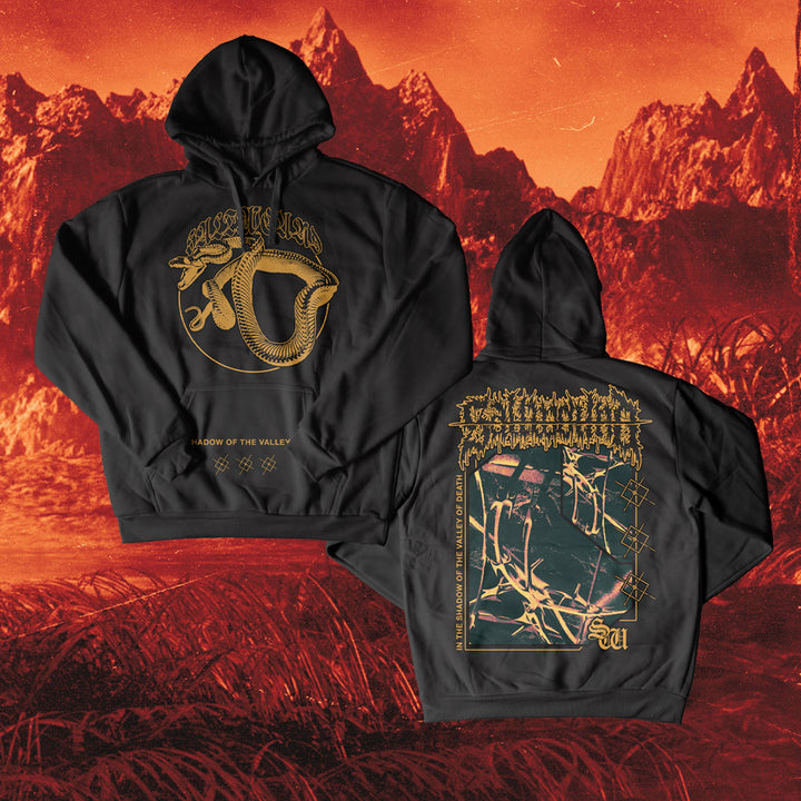 Two black Saltwound pullover hoodies with gold designs—one shows a coiled snake and text, the other ornate lettering and graphics. Both are classic fit, displayed against a bold red-orange mountain landscape.