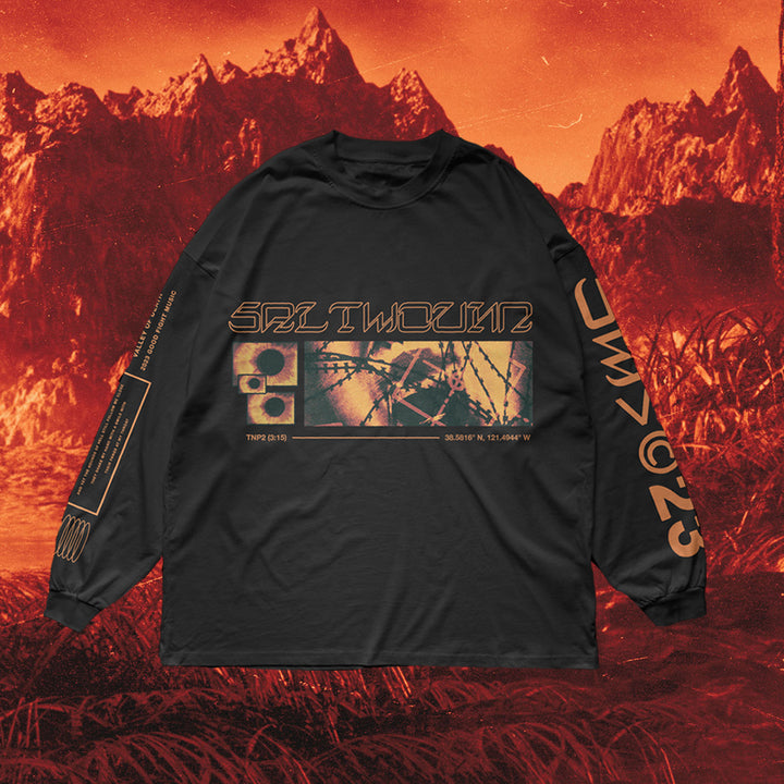 A black Saltwound long-sleeve shirt features futuristic, distorted beige and orange graphics on the front and sleeves, set against an orange-tinted mountainous landscape background.
