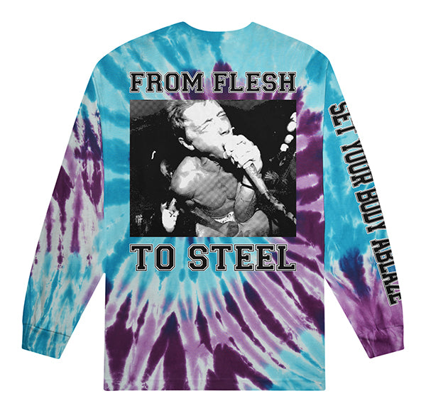 A tie-dye long-sleeve shirt in blue, purple, and white from Shai Hulud features a black-and-white vocalist photo. “FROM FLESH TO STEEL” appears on the front; “SET YOUR BODY ABLAZE” is printed on the sleeve.