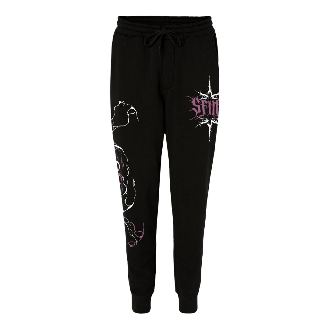 SFINX black sweatpants with a drawstring waist, white abstract line art on the right leg, and a purple SFINX graphic with text on the left hip, shown against a plain white background.