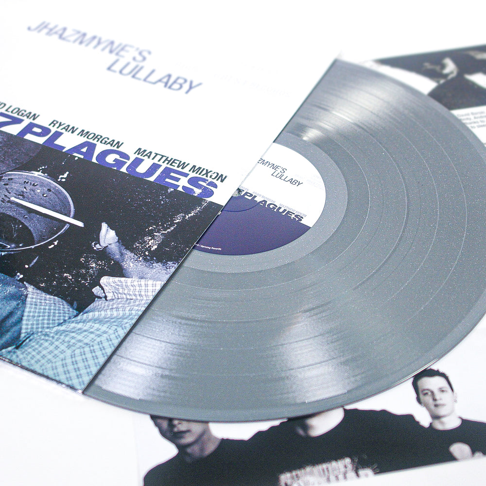 A silver glitter vinyl record partially slides out of its cover, which displays the text PLAGUES and images of band members. Other album artwork and band photos are visible in the background, highlighting this special limited edition vinyl release.