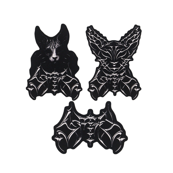 Three black-and-white stickers: two stylized bat heads with intricate patterns at the top, and one abstract bat body with wings and detailed linework at the bottom, all set against a white background.