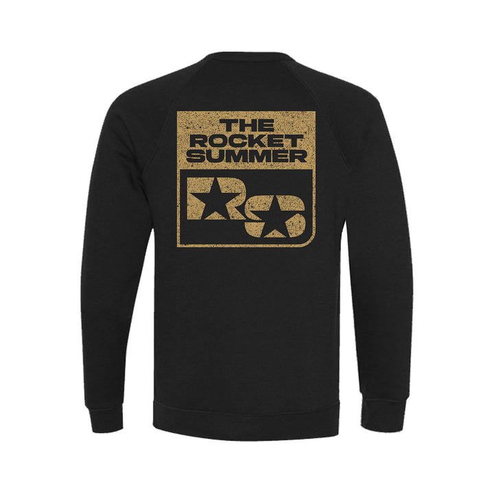 A black unisex Bella + Canvas Raglan Crewneck by The Rocket Summer, featuring a large distressed gold graphic on the back with "The Rocket Summer," two stars, and bold RS letters for perfect comfort and style.