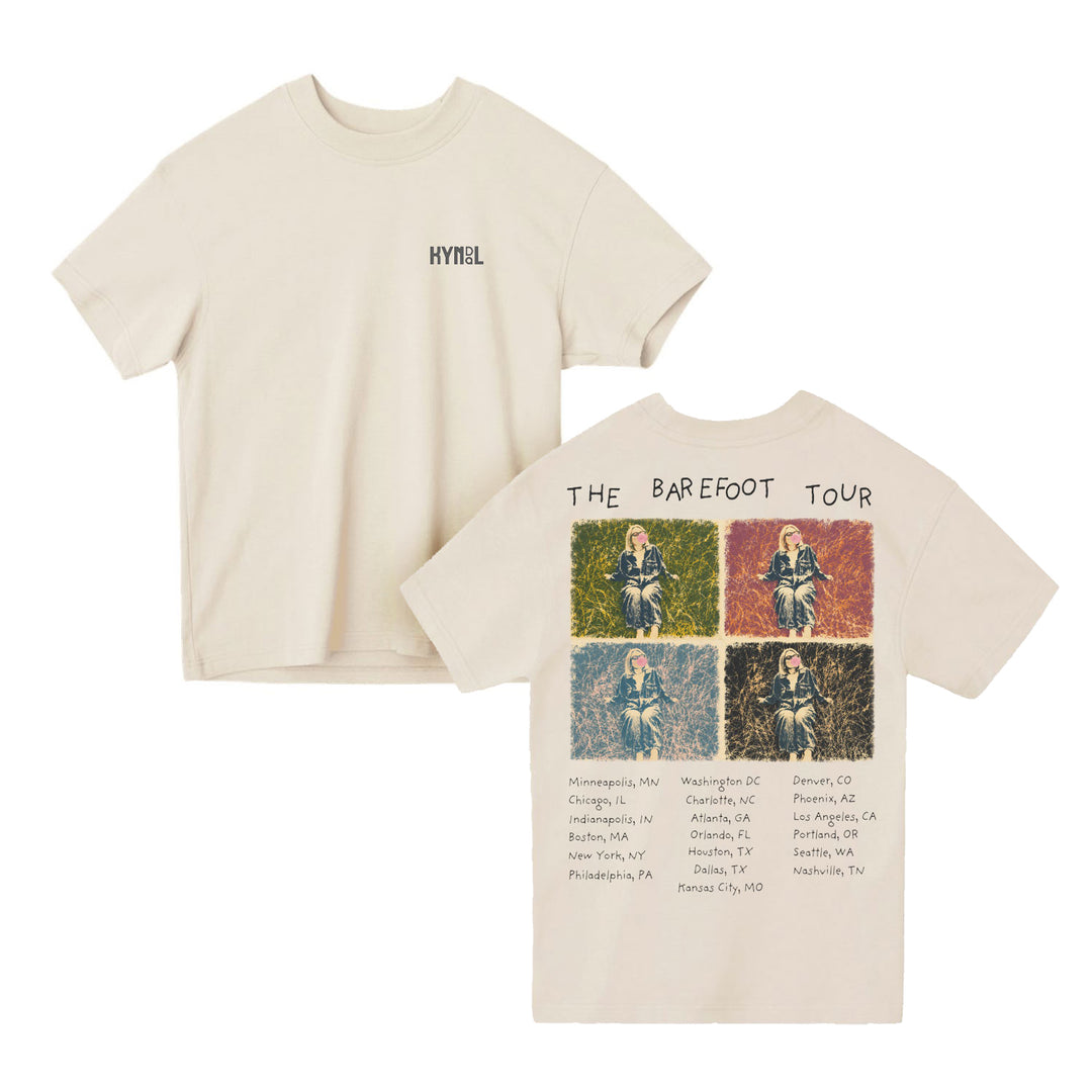Beige Kyndal Lane Seven T-Shirt with HYNESL on the front left chest. Oversized boxy fit and heavyweight pigment-dyed jersey. Back features THE BAREFOOT TOUR, four colorful sitting photos, and a list of cities and states.