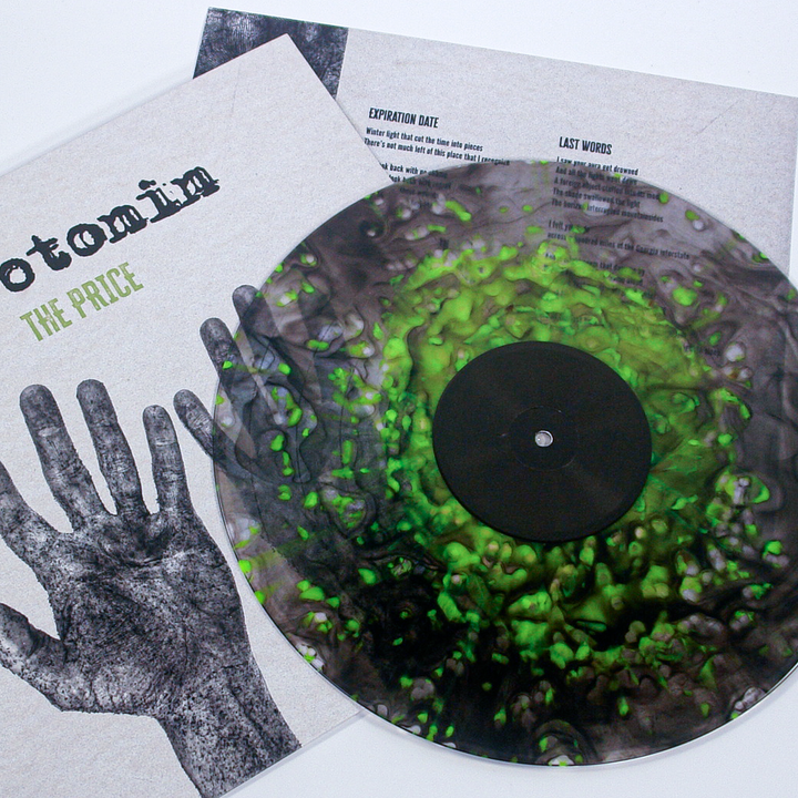 Vinyl record with green and black marbled color, shown partially inside its sleeve for the Serotonin emo punk album Otomin: The Price, which features a black and white image of a human hand.