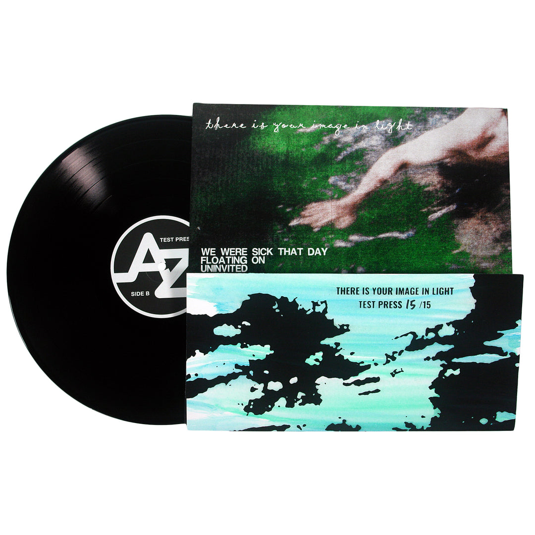 A black 12” vinyl record by King Slender is partially out of its sleeve, featuring abstract green and blue cover art and displaying emotional hardcore tracks: We Were Sick That Day, Floating On, Uninvited, and There Is Your Image in Light.
