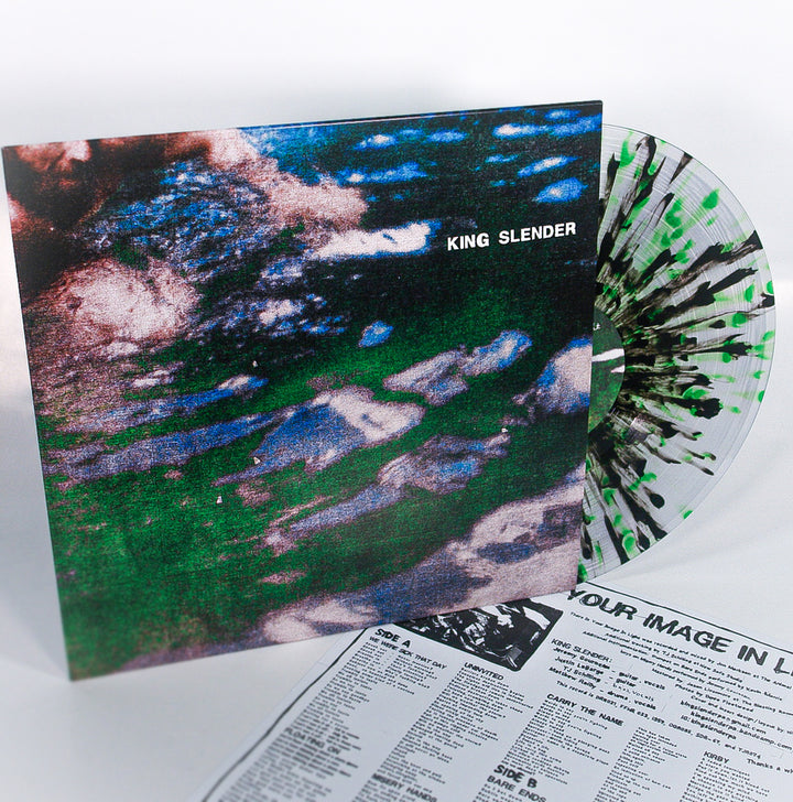 A vibrant 12" King Slender vinyl with green, white, and black splatters peeks from its abstract cover, while a black-and-white lyrics sheet lies underneath this striking emotional hardcore release.