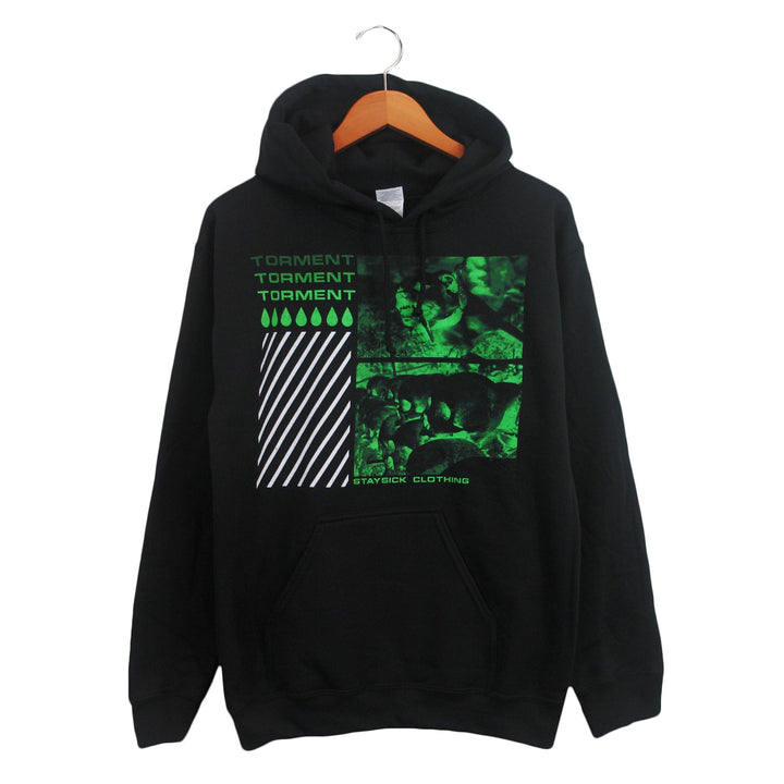 Black hoodie by Stay Sick Clothing on a wooden hanger, showcases green and white TORMENT graphics, diagonal white stripes, geometric shapes, abstract images, and STAY SICK CLOTHING text at the bottom.