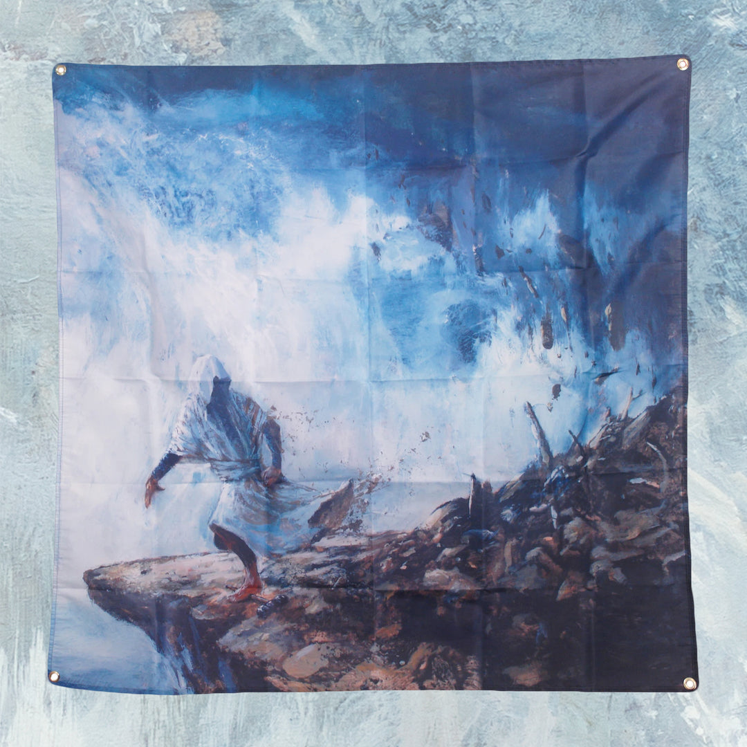 A hooded figure stands on a rocky cliff before a swirling blue and white storm, debris scattered and misty air behind—an epic scene printed on a Cryptodira 4' x 4" wall flag with sturdy grommets.