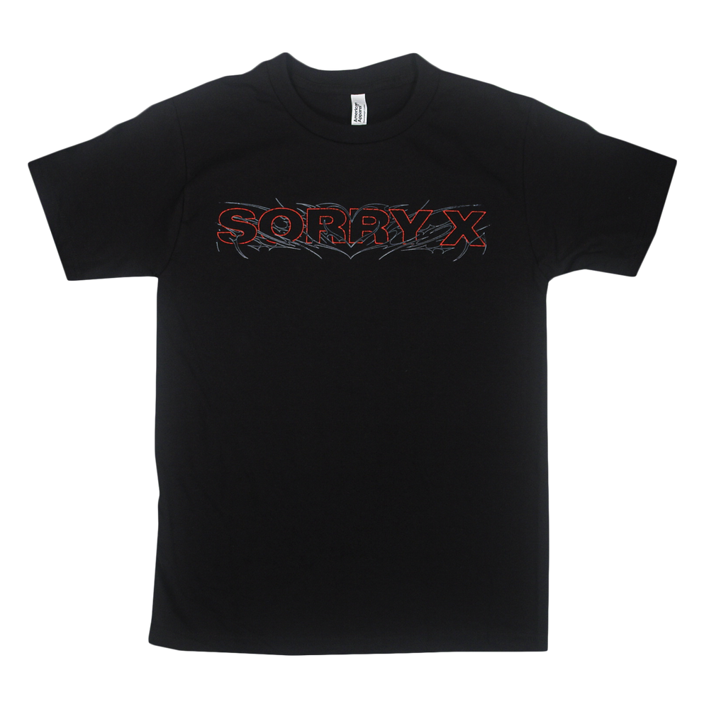 Black American Apparel t-shirt by Sorry X featuring the words “SORRY X” in bold red outlined text across the chest, accented with a spiky, flame-inspired design around the lettering. Made from 100% U.S. cotton, this relaxed fit tee is plain with no additional graphics.