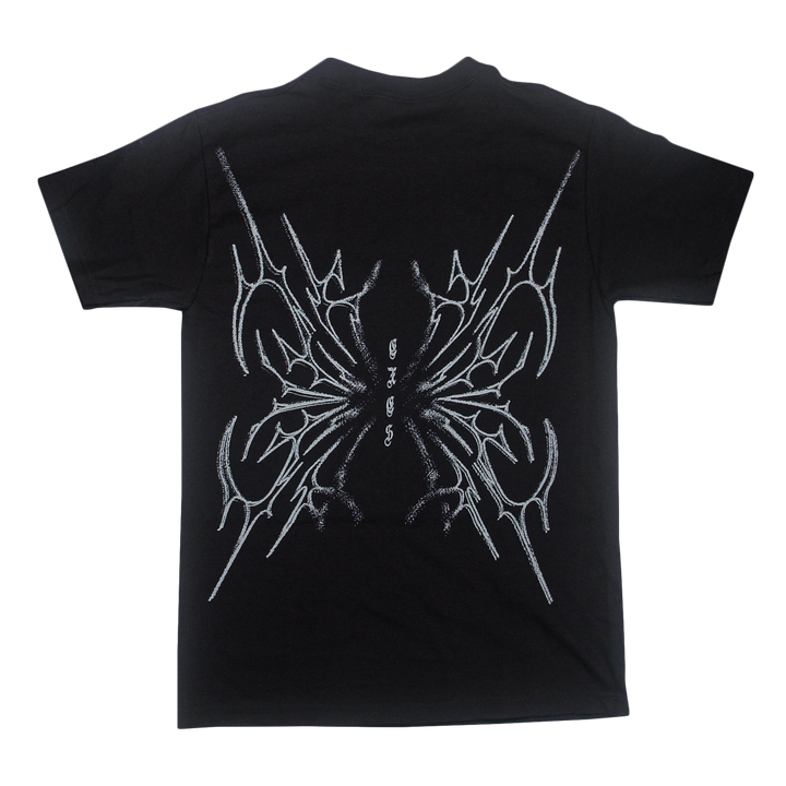 Black t-shirt by Sorry X, crafted from 100% U.S cotton, featuring an abstract, symmetrical white line design on the back that resembles sharp intersecting shapes or wings. Includes small stylized text in the center and offers a relaxed fit inspired by classic American Apparel T-Shirts.