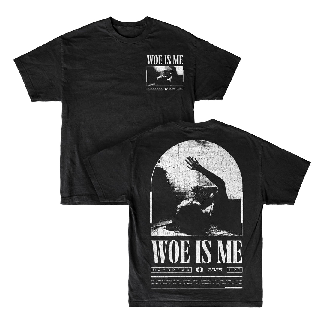 Woe Is Me black T-shirt featuring Woe Is Me text and a grayscale image of a person raising an arm on both sides. Back includes DAYBREAK | 2025 | LP3 and graphics—ideal for fans awaiting LP3 or collecting black vinyl editions.