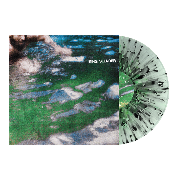A vinyl record partially in its sleeve. The sleeve shows a blurry green-and-blue water design with "King Slender" in white text. The record, by brand King Slender, has a unique green and black splatter pattern.