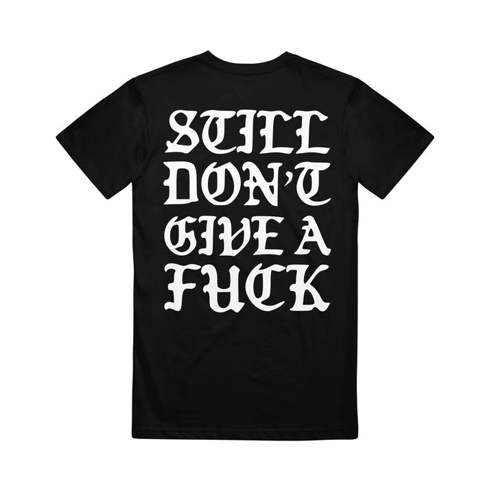 This bold black graphic tee from Stay Sick Clothing features striking white gothic-style text on the back that reads, STILL DONT GIVE A FUCK.