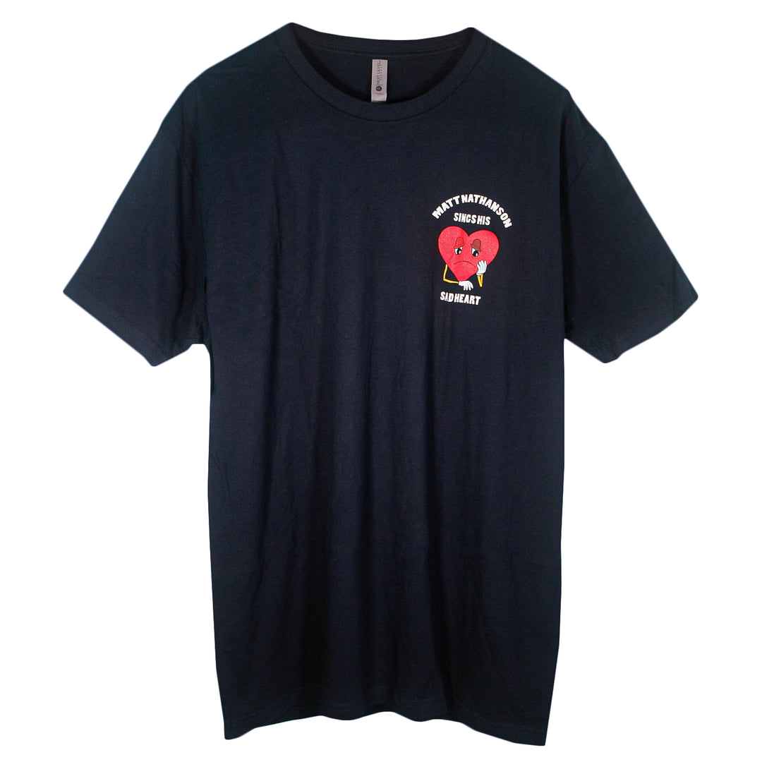 Black Matt Nathanson T-shirt with a small graphic on the left chest showing a red broken heart, cartoon figure, and the text "HEART MATAMOROS" above and "SADHEART" below.