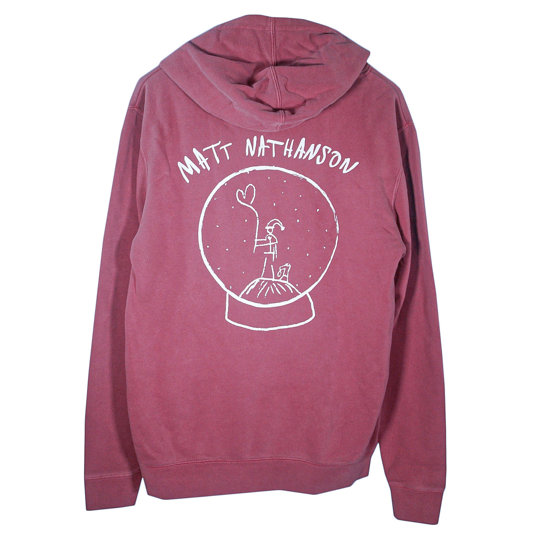A maroon Matt Nathanson hoodie with his name above a white snow globe line drawing featuring a person holding a balloon and a dog inside. Ideal for fans seeking cozy, uniquely designed printed pullovers.