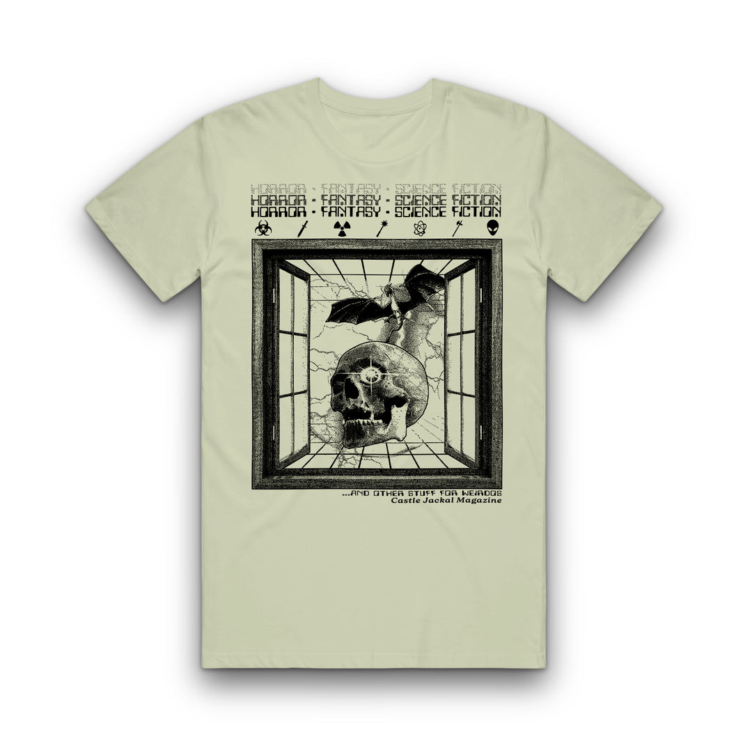 The Castle Jackal Comfort Colors tee features a cracked window with a skull and bat. “Horror Fantasy Science Fiction” repeats in a vintage font above. Pre-order for classic style and chilling design.