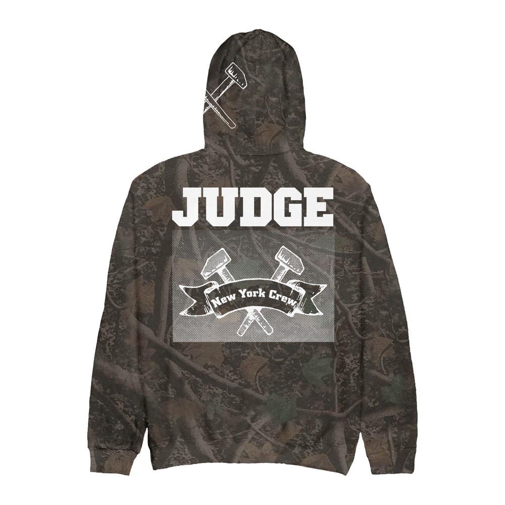 Back view of an IND4000 camouflage hoodie featuring a JUDGE and New York Crew banner graphic with crossed hammers.