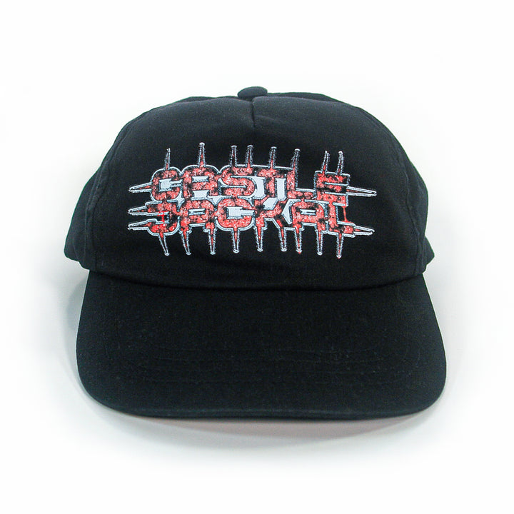 A black Castle Jackal 5-panel Yupoong Classics snapback features jagged red and white embroidered text with spike accents. Displayed on a white background.