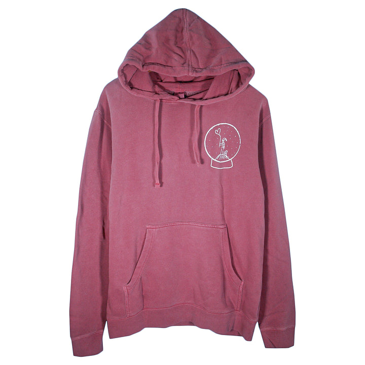 A maroon Matt Nathanson pigment-dyed pullover hoodie with a front pocket and drawstrings, featuring a small white peace sign hand in a snow globe graphic on the left chest.
