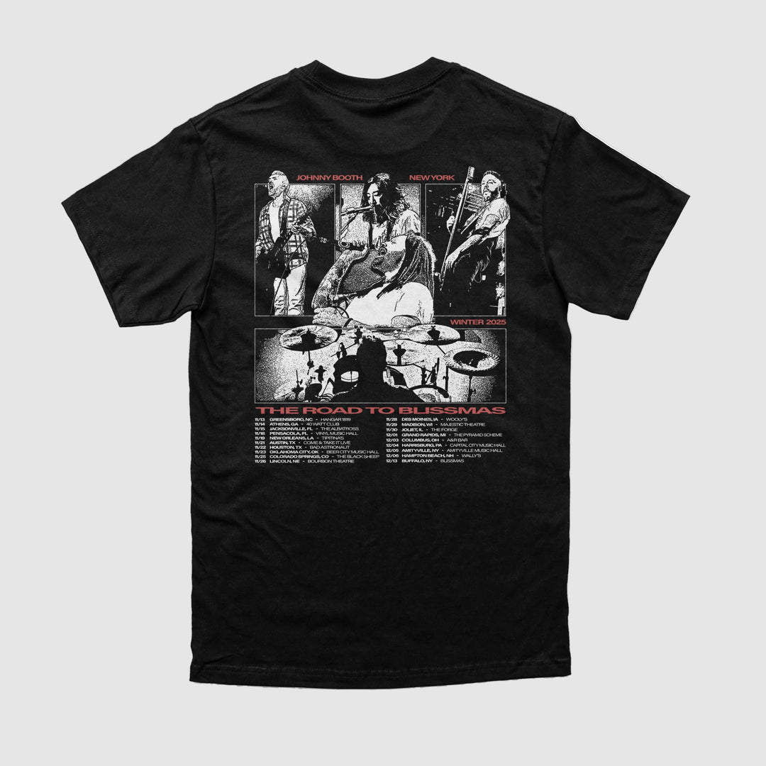 The Johnny Booth black t-shirt, made from Comfort Colors, features a white and red back graphic of four musicians performing with a drum set silhouette and "The Road to Blissmas" above tour dates—ideal for printed apparel fans.