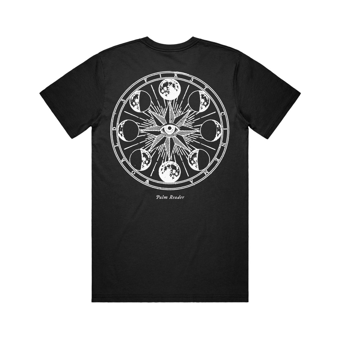 Black Comfort Colors t-shirt by World’s First Cinema featuring a bold white eye and moon phases graphic on the back, with “Palm Reader” below. Ideal for fans of unique custom apparel.