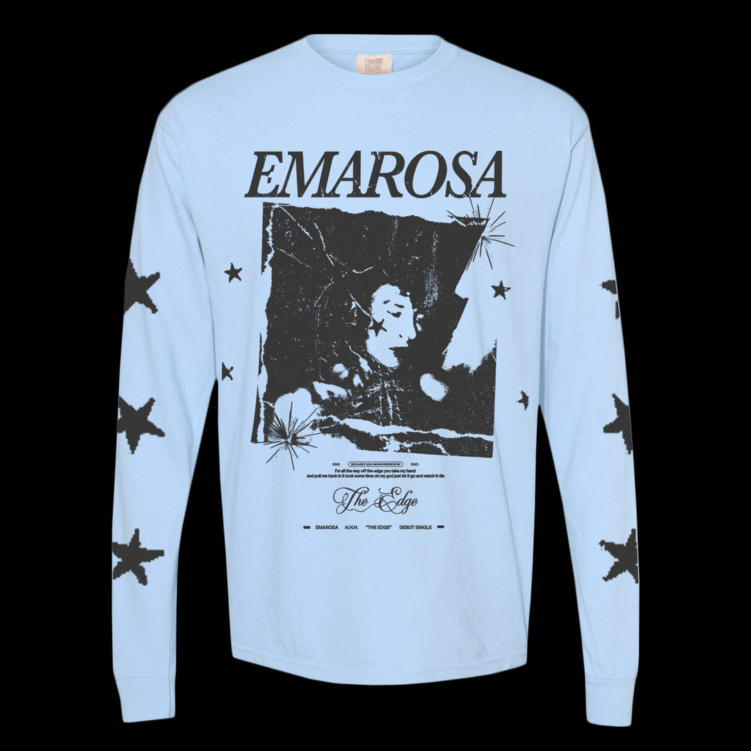 Light blue Emarosa Comfort Colors long-sleeve t-shirt featuring black stars on the sleeves, "EMAROSA" on the front above a black-and-white person image, and additional text including “The Edge.”.