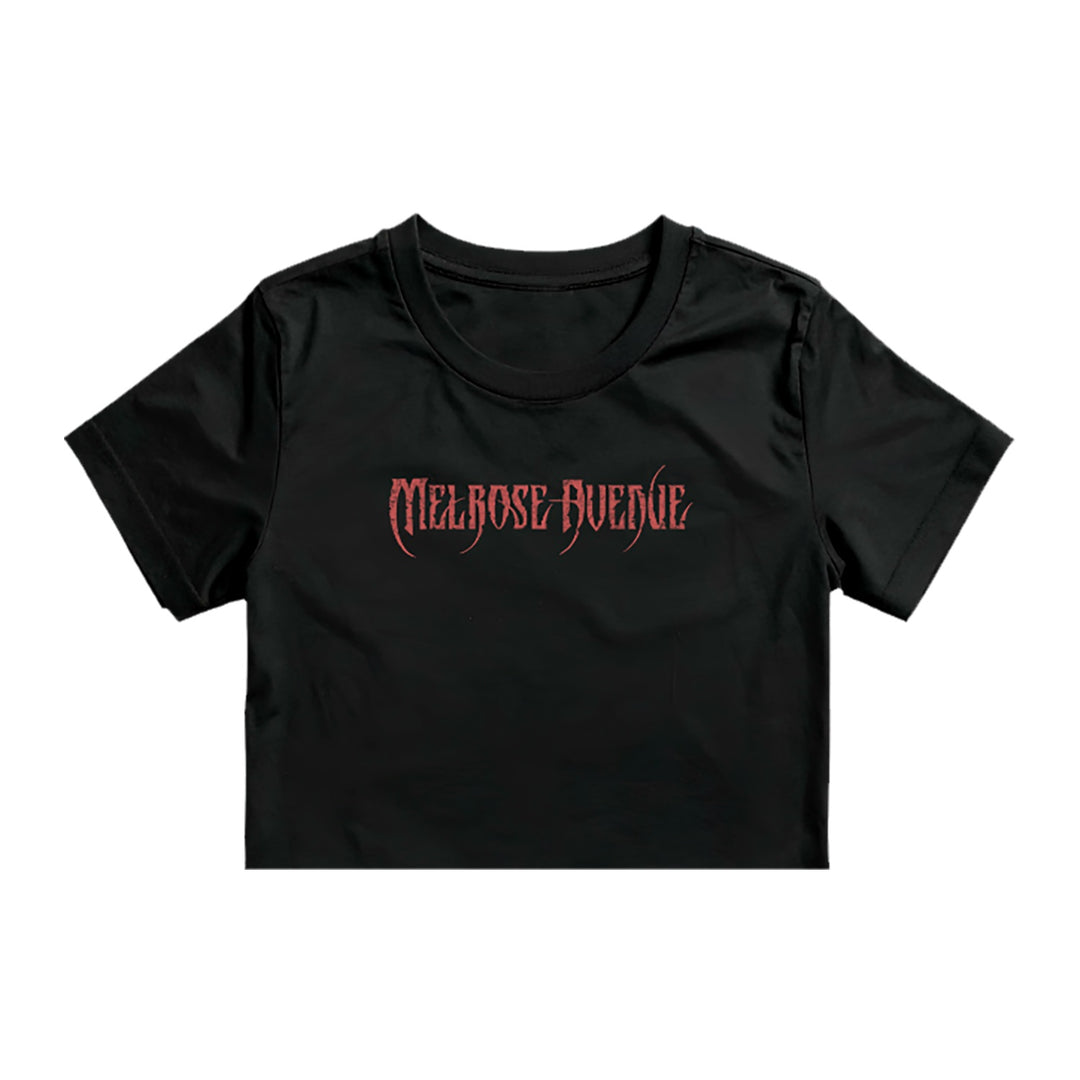 A black Melrose Avenue crop tee by ASColour 4062, made from 100% combed cotton, features bold red gothic-style "MELROSE AVENUE" lettering on the front.