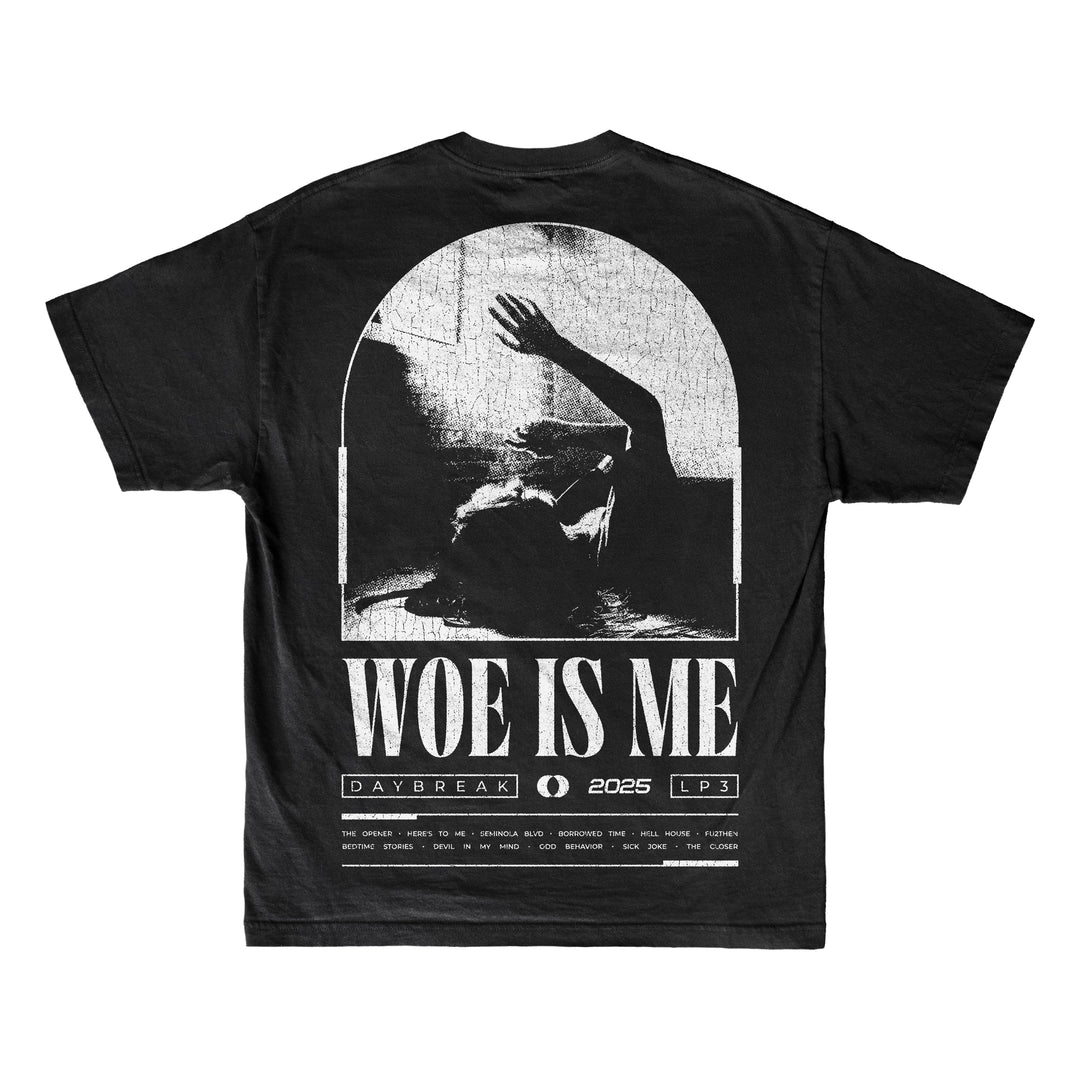 Woe Is Me black T-shirt with a grayscale figure reaching up inside an arched window, bold Woe Is Me text, and smaller details: DAYBREAK, 2025, LP3.