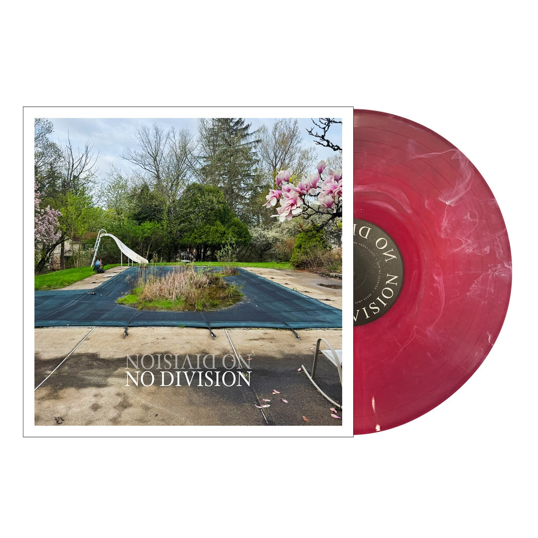A pink marbled No Division vinyl partially slides from its cover, which features an overgrown backyard pool surrounded by trees and flowers. "NO DIVISION" is printed at the bottom, highlighting the No Division brand.
