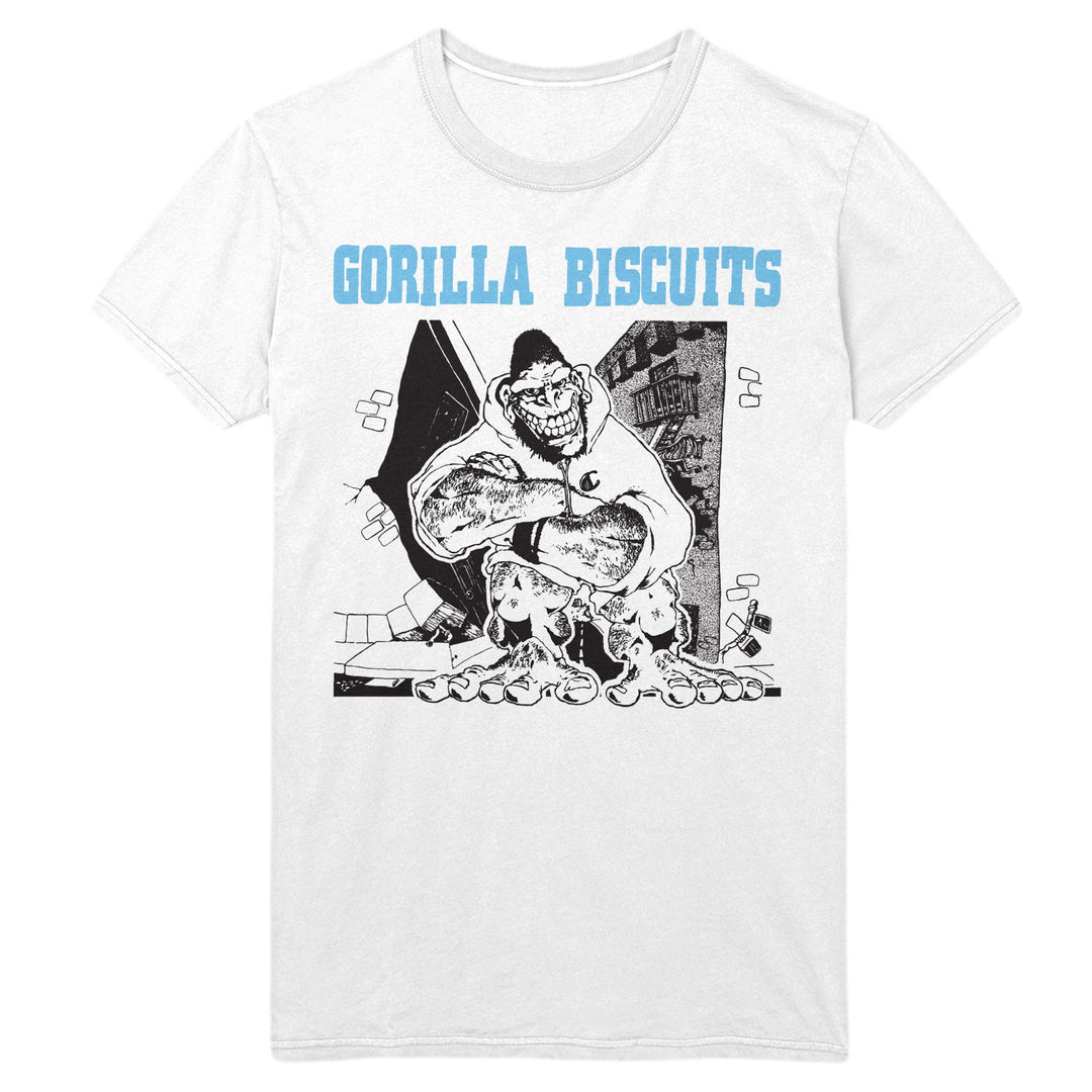 White Gildan Heavy Cotton t-shirt by Gorilla Biscuits featuring a cartoon gorilla hugging a biscuit with distressed buildings behind, and "GORILLA BISCUITS" in large light blue letters above the illustration.