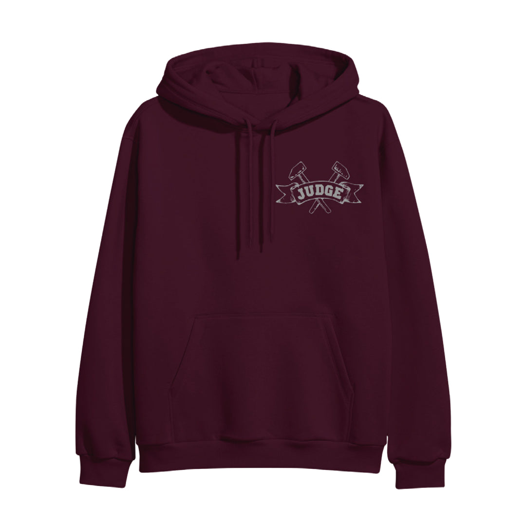A maroon Judge heavy cotton hoodie with front pocket, featuring a small crossed axes and "JUDGE" banner graphic on the left chest. Available for presale; ships 11/28/2025.