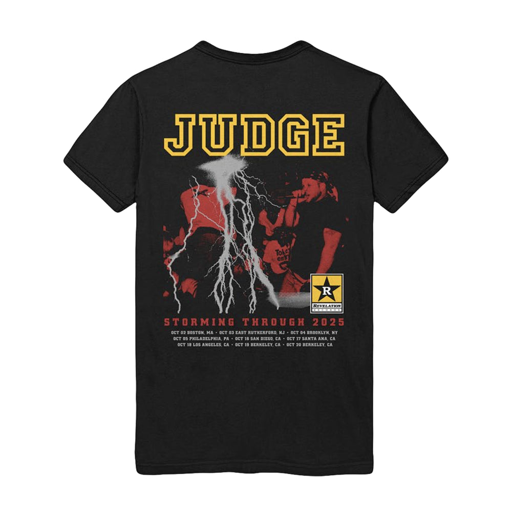 Black heavyweight cotton tee by Judge with bold yellow band name, live performance photo, white lightning, Rated R emblem, and “Storming Through 2025” tour dates printed at the bottom.