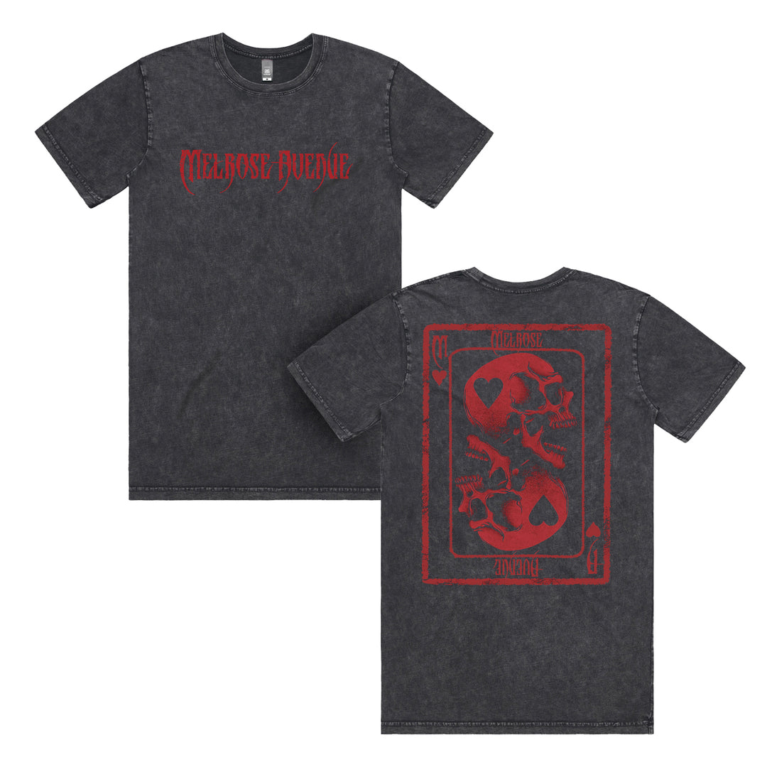 Front and back of a black stone wash Melrose Avenue tee. The front has red gothic MELROSE AVENUE text; the back features a large red playing card graphic with skulls, hearts, and Melrose Avenue branding on an AS Colour staple tee.