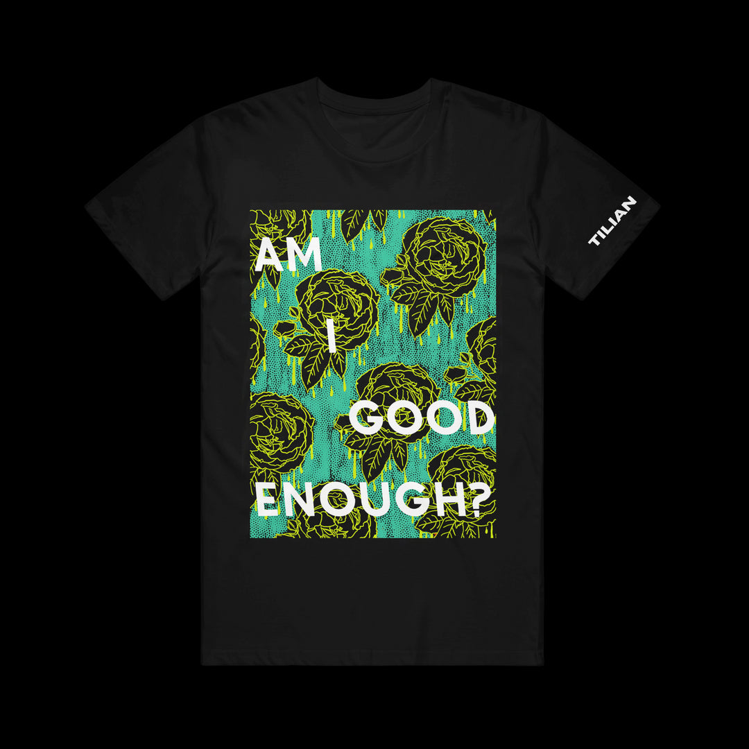 Tilian black t-shirt featuring a turquoise and yellow abstract floral print with AM I GOOD ENOUGH? in bold white text on the front. TILIAN is printed in white on the right sleeve.